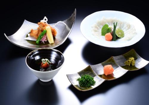 four dishes of food on plates on a table at Balinese onsen ryokan Hakone Airu in Hakone