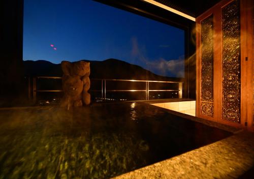 a view of a swimming pool at night at Balinese onsen ryokan Hakone Airu in Hakone