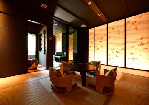 a living room with a table and chairs in a room at Balinese onsen ryokan Hakone Airu in Hakone