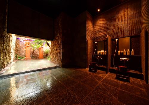 a bathroom with a sink in a brick wall at Balinese onsen ryokan Hakone Airu in Hakone