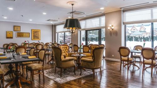a room with chairs and tables and windows at Hotel Paryski Art & Business Zakopane - Basen Jacuzzi Sauna Małpi Gaj in Zakopane