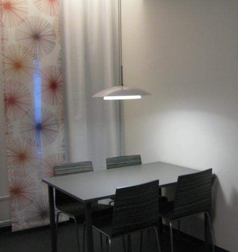 a dining room table with chairs and a pendant light at Santasport Resort in Rovaniemi