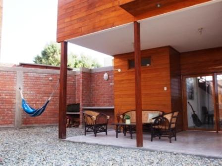un patio con sillas, una mesa y una pared de ladrillo en Los Maderos de Colan: Casa #5 +BBQ+Pool+WiFi, en Colán