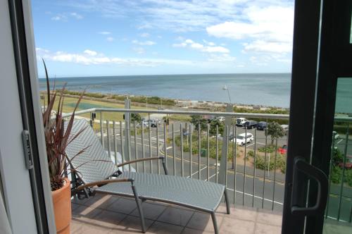 a balcony with two chairs and a view of the ocean at Millennium Hotel New Plymouth, Waterfront in New Plymouth