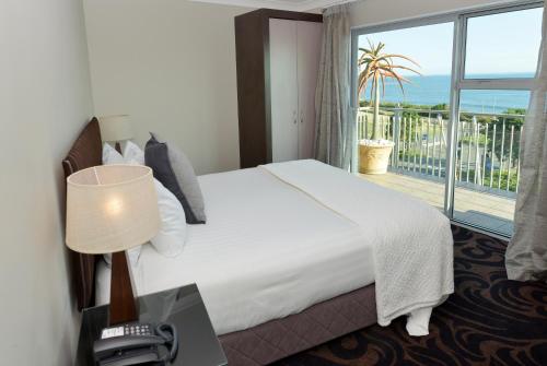 um quarto de hotel com uma cama e uma varanda em Millennium Hotel New Plymouth, Waterfront em New Plymouth