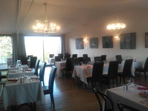 une salle à manger avec des tables, des chaises et des lustres dans l'établissement L'Auberge de Teissières, à Teissières-lès-Bouliès