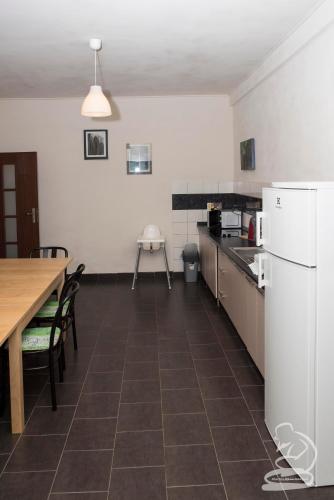 a kitchen with a table and a white refrigerator at U Kosti - Bohemian Switzerland in Děčín