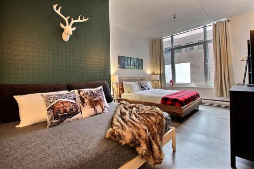 a bedroom with a bed and a couch and a window at INITIAL - LOFT FORESTIER - Centre-Ville de Québec in Quebec City