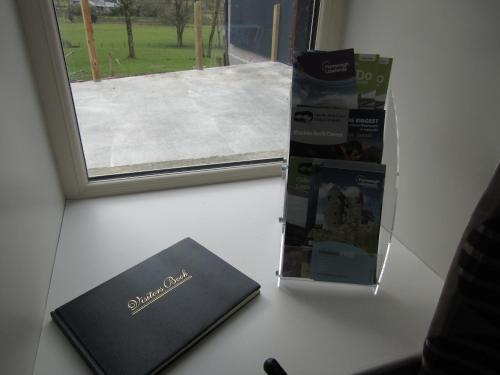 a book sitting on a desk next to a window at Knockninny Barn at Upper Lough Erne, County Fermanagh in Enniskillen