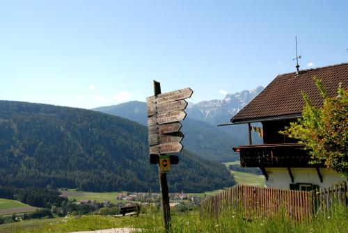 a directional sign on a hill near a house at Garni Renzler in Rasun di Sopra