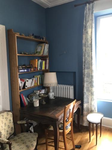 une salle à manger avec une table et une étagère à livres dans l'établissement Chez Auguste, à Nancy