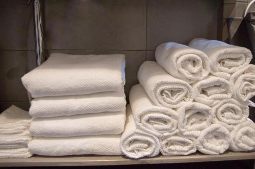 een stapel handdoeken op een plank in een badkamer bij Bed en breakfast Uitrust in Lauwerzijl
