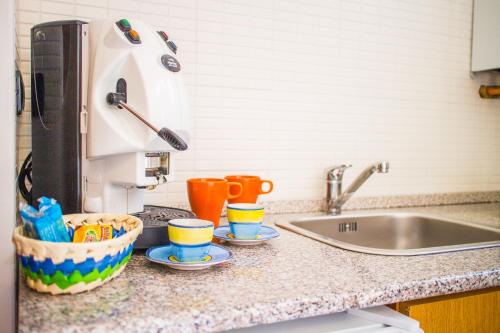 eine Küchentheke mit Spüle und Tassen darauf in der Unterkunft Dimore dei Marinai Termoli in Termoli