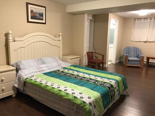 a bedroom with a large bed and a chair at Sweet home in Moncton