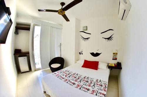 a bedroom with a bed with a face on the wall at Hotel Florida Sincelejo in Sincelejo