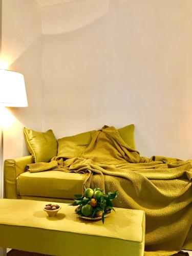 a green bed with a table with a bowl of fruit on it at Agriturismo Giorgio in Mattinata