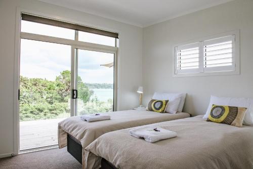 En eller flere senge i et værelse på Te Whau Bach Apartments