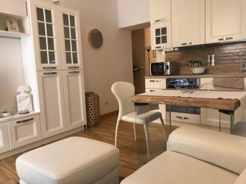 a kitchen with white cabinets and a table and chairs at Rome dreaming house in Rome