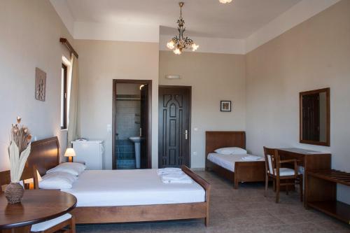 a hotel room with two beds and a table at Calypso Apartments in Vathi, Ithaka