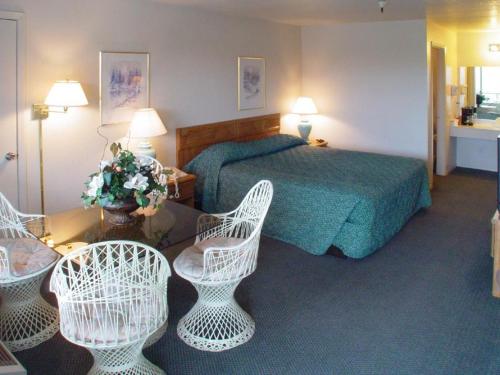 pokój hotelowy z łóżkiem i 2 krzesłami w obiekcie Applegate Inn w mieście Atwater