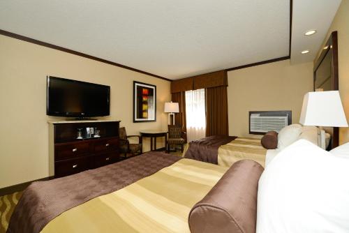 a hotel room with two beds and a flat screen tv at Siding 16 Lodge in Wetaskiwin