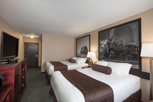 a hotel room with two beds and a flat screen tv at Siding 16 Lodge in Wetaskiwin