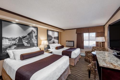 a hotel room with two beds and a flat screen tv at Siding 16 Lodge in Wetaskiwin