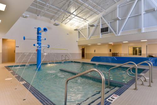 a large swimming pool with a water fountain at Siding 16 Lodge in Wetaskiwin