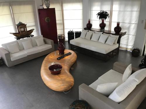 sala de estar con sofás y mesa de madera en The Whitehouse by the Sea, en Panglao