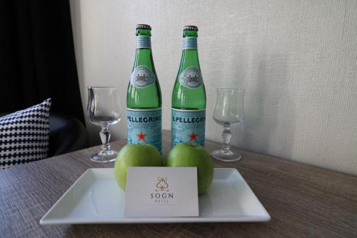 two bottles of soda sitting on a table with apples and glasses at Sogn Hotel in Vadheim