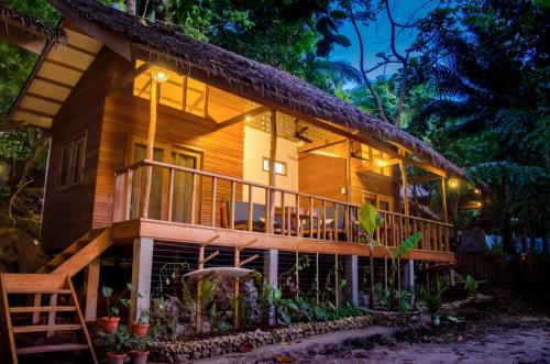 a wooden house with a deck at night at Amihan Bungalows in General Luna