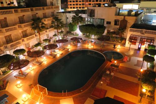 an overhead view of a pool with tables and umbrellas at Zak Inn in Hurghada