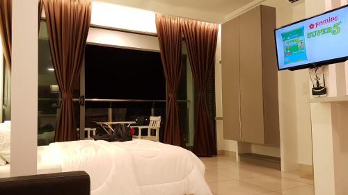 a bedroom with a bed and a flat screen tv at EVO SOHO STUDIO Suites in Kampong Sungai Ramal Dalam