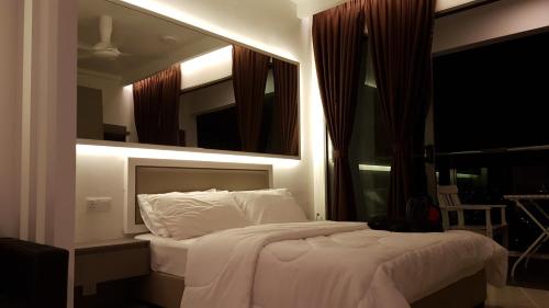 a bedroom with a large white bed with a mirror at EVO SOHO STUDIO Suites in Kampong Sungai Ramal Dalam