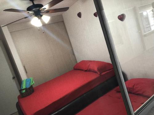 Zimmer mit einem roten Bett und einem Deckenventilator. in der Unterkunft Eclipse in Guadalajara
