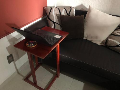 a laptop on a table next to a couch at Eclipse in Guadalajara