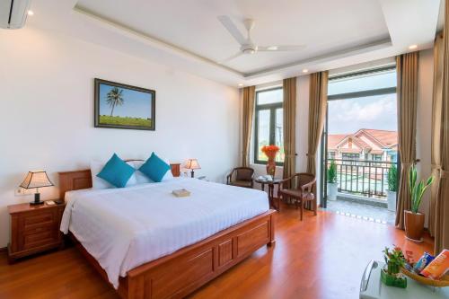 a bedroom with a large bed and a balcony at An Bang Beach Dolphin Homestay in Hoi An