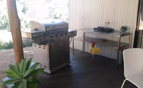a chicken standing next to a grill in a room at Avoca Beach and Bush in Avoca Beach