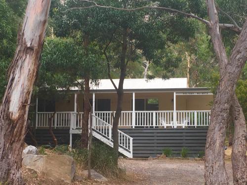 a house with a porch and white railing at Holiday Heights in Halls Gap