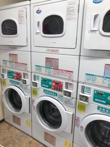 four washing machines are lined up in a laundromat at Hatoya Hotel in Tokyo