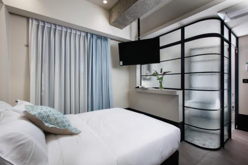 a bedroom with a white bed and a window at Oia Hotel Dadaepo in Busan