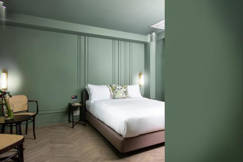 a bedroom with a white bed and a table and chairs at Oia Hotel Dadaepo in Busan