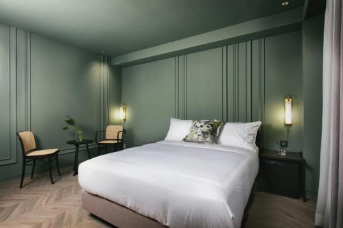 a bedroom with a large white bed and a table at Oia Hotel Dadaepo in Busan