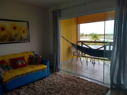 a living room with a couch and a hammock at Apto Villa das Aguas in Estância