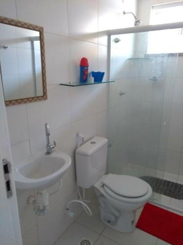 a bathroom with a toilet and a sink and a shower at Apto Villa das Aguas in Estância