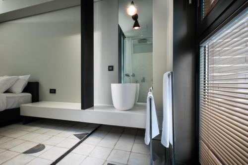 a bathroom with a tub and a sink in it at Oia Hotel Dadaepo in Busan