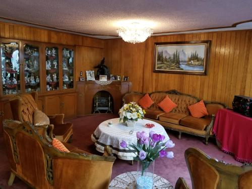 a living room with a table with flowers on it at Casa Q BnB in Mexico City