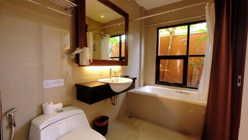 a bathroom with a toilet and a sink and a mirror at Sari Villa Sanur Beach in Sanur