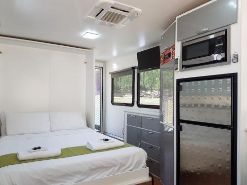 a small room with a bed and a refrigerator at Moama on Murray Houseboats in Moama
