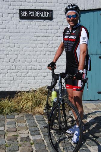 a man is standing next to a bike at Polderlicht in Blankenberge